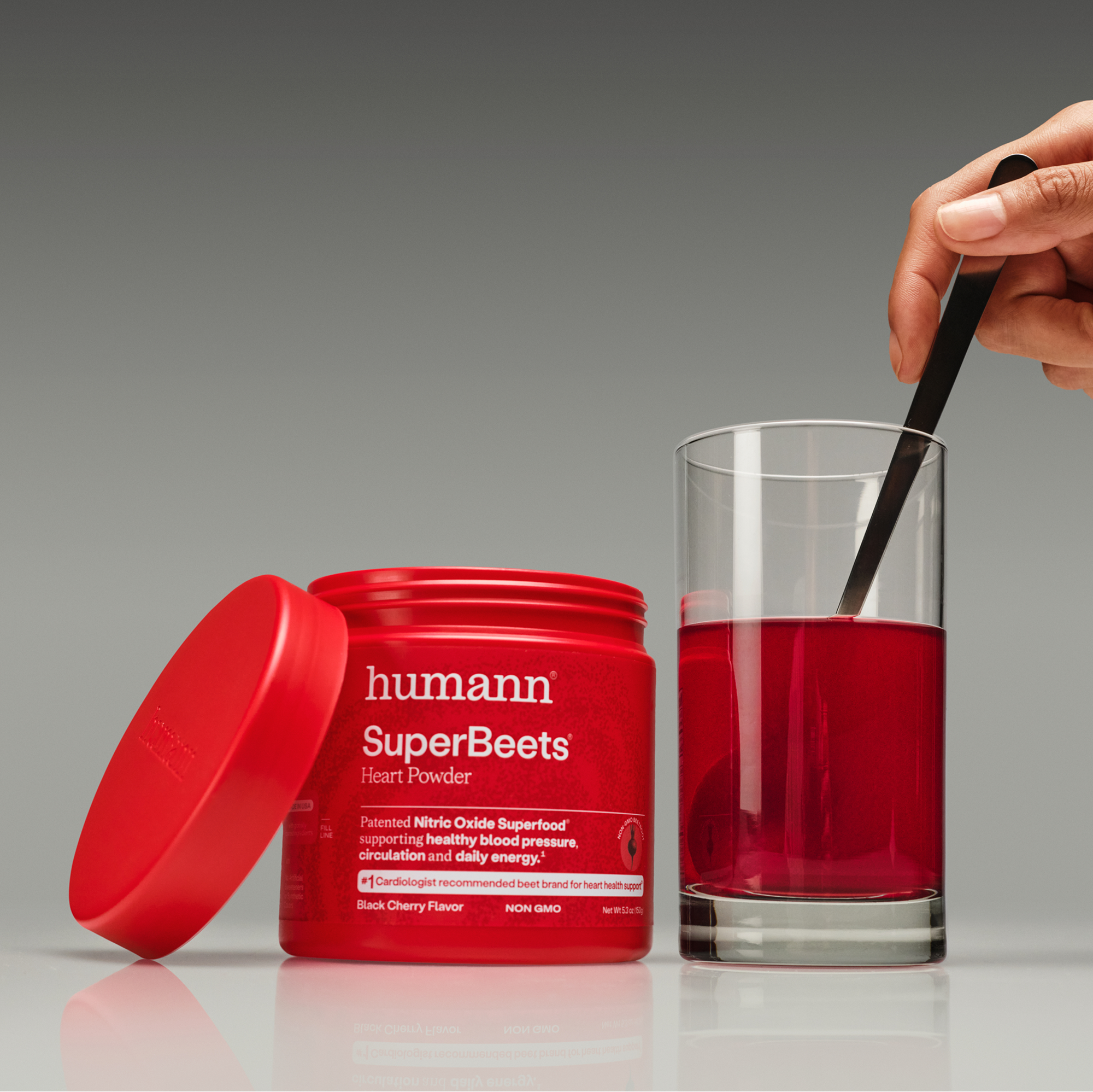 A man using a spray bottle on a large plant leaf.