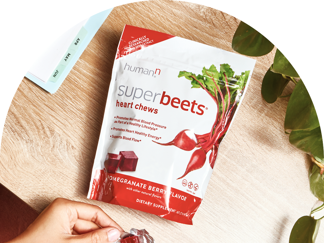Superbeets Heart Chews Advanced package with gold wrapped chews. Sunglasses and a leather wallet are on either side.